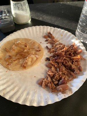 Carnita taco with beans And on the Taco are pieces of plastic that I found in my taco