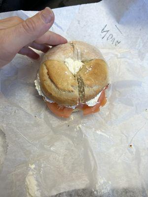 Huge salt bagel with lox, cream cheese, capers, and sliced red onion