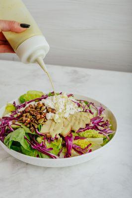 Maple Feta Salad. Little Gem Lettuce, Purple Cabbage, Maple'd Walnuts & Pumpkin Seeds, Feta, Sliced Apple, Maple Sage Vinaigrette.