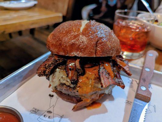 EMMY BURGER - Pat LaFrieda dry aged beef, EMMY sauce, caramelized onion, Grafton cheddar, on a pretzel bun with cornichon & fries