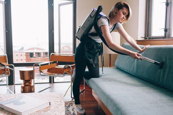 Vacuuming the upholstery at a routine cleaning, in-town Portland.