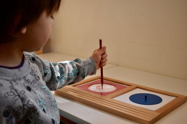 A child working with the Circle Metal Inset