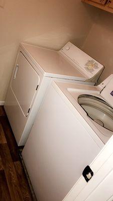 Washer and dryer in laundry room. Cabinets above for storage.