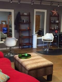 The comfy red waiting area sofa, with two hair stations in the background.