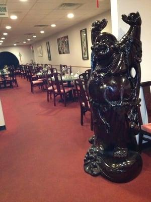 You are welcomed by a laughing Buddha into a comfortable dining room.