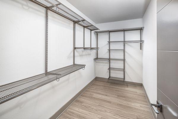 Spacious walk-in closet with dress, suit and hat racks.