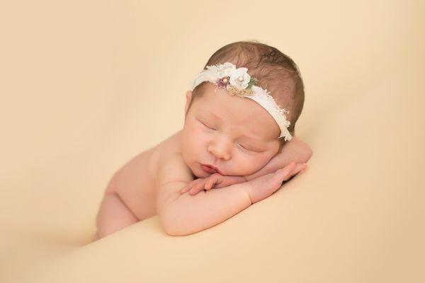 Naken newborn girl posed on butter cream yellow blanket leaning on wrists and tushie up Gainesville FL photos