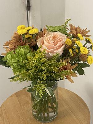 This gorgeous arrangement is so appealing and have a calming effect includes;
 Peach roses, Yellow Buttons , Green Hydrangeas bronze cushion