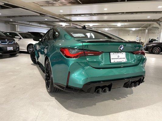 2022 BMW M4 in Isle of Man Green Metallic. Equipped with a 6-speed manual transmission.