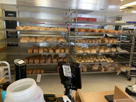 Rack of breads that are cooking off, but you're still able to buy!