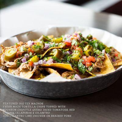 Big Tex Nachos - Fresh made tortilla chips topped with bourbon chipotle queso, diced tomatoes, red onions, jalapenos & cilantro