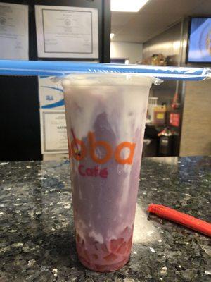 Taro milk tea with strawberry jelly and milk cap in a large.