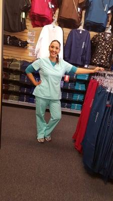 A lovely customer trying on new scrubs for their office group order. Group order discounts available. See store for details today!