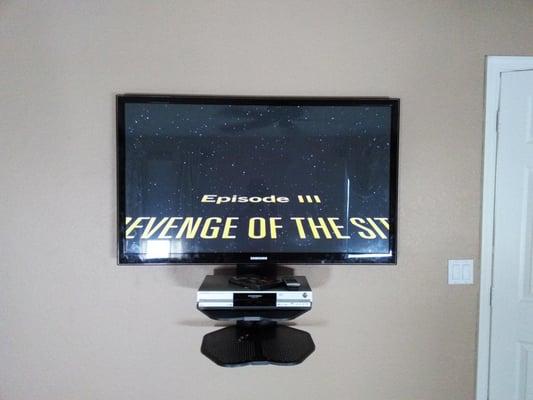 55' TV mounted with shelves and blueray player