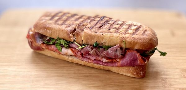 Daniele - panini - Prosciutto, Sopresatta, cappicollo, fresh mozzarella, Arugula, vine ripe tomatoes, evoo, Balsamic, w/ pickle & chips