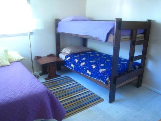 Bedroom in Guest House at Aqua Casa Vacation Homes. One full size bed and two bunks.