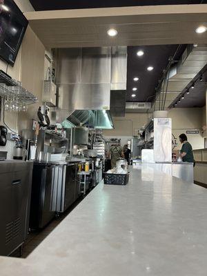 Counter seating view of the cooks. Waiting on my lunch to go.