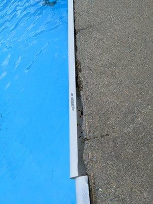 Broken cheap fix of rim around pool - nobody hurt themselves on it, but someone could very easily.