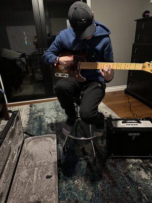 He's in LOVE with his new Fender American Professional guitar, Boss Amp and Roc N Soc stool.