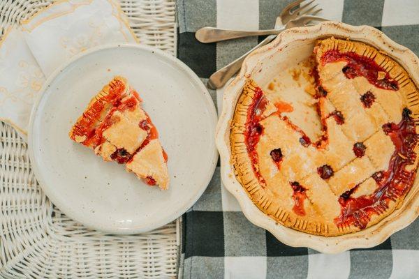 Fluted pie plate and salad plate serving up a warm cherry pie.