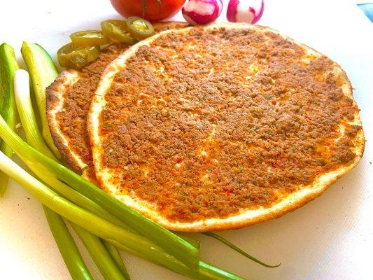 Lahmajun (Armenian pizza) Fresh lean ground beef mixed with finely chopped vegetables, layered on top of a thin round dough.