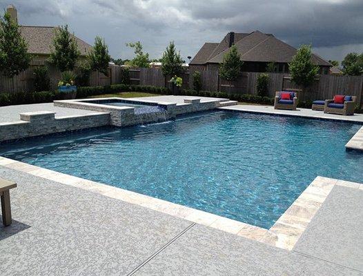 Geometric pool with square spa with water spillover