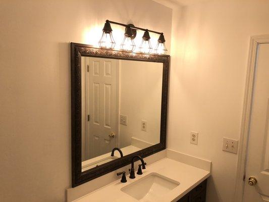 Framed mirror , light fixture, countertop