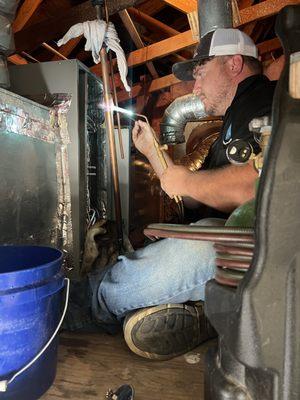 Owner Shane Dobkins careful brazing an existing  line set to a new evaporator coil.