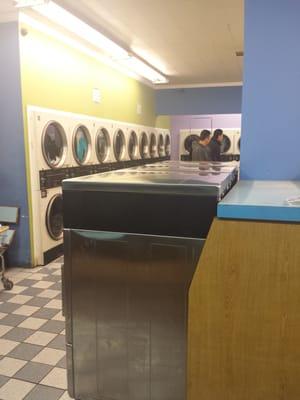 Tons of dryers. Top and front loading washers.Flat screen TV playing.