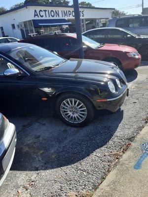 Older model Jaguar in the parking lot awaiting repairs