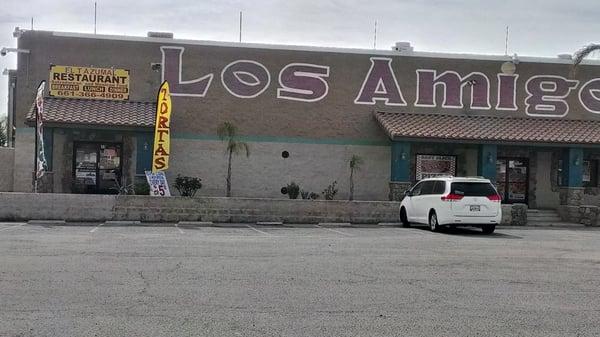 The restaurant is located at the front left corner of a big building that is a flea market inside.