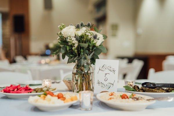 Delicate guest table center piece with lots of greenery I requested by by Mother Earth Flowers. Photo by Emily Rammelsberg Photography.