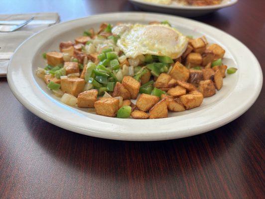 Breakfast potatoes with peppers and onions and an over-medium egg