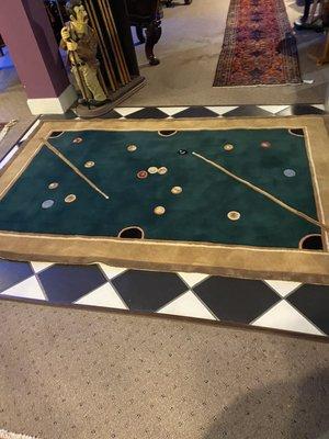 This a rug with the design of pool table .