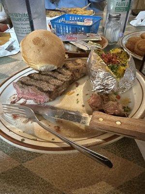 NY Strip medium rare with a loaded backed potato and a role.