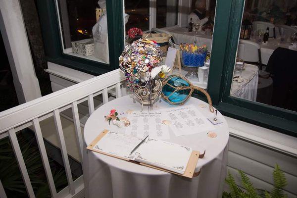 Guest book, bouquet stand, and seating assignments by the doors.