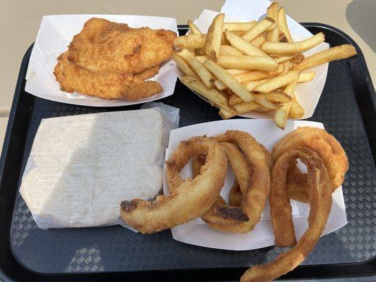 Two Piece Fish Sandwich on Rye Bread with Fries and Onion Rings