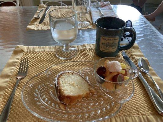 Homemade almond bread with fruit cup and cantaloupe ice cream.