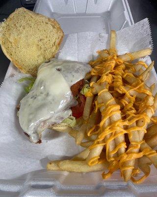 Crispy chicken sandwich on a roll with lettuce tomatoes with cheese fries