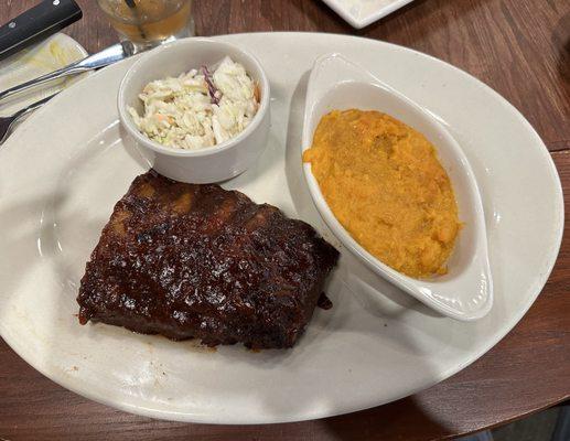 Half slab of ribs with coleslaw and mashed sweet potatoes.