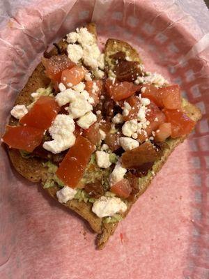 Avocado toast with feta cheese, diced tomatoes, and bacon.