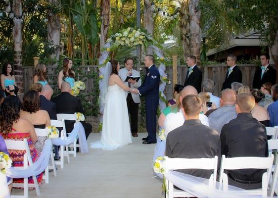 white wooden folding chairs and rustic arch