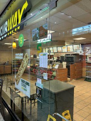 Sign showing their opening hours and the fact they're not closing despite only having two loaves of bread left.