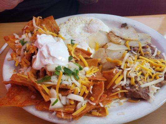 Chiliquitos breakfast plate with beans, sliced potatoes and fried eggs.