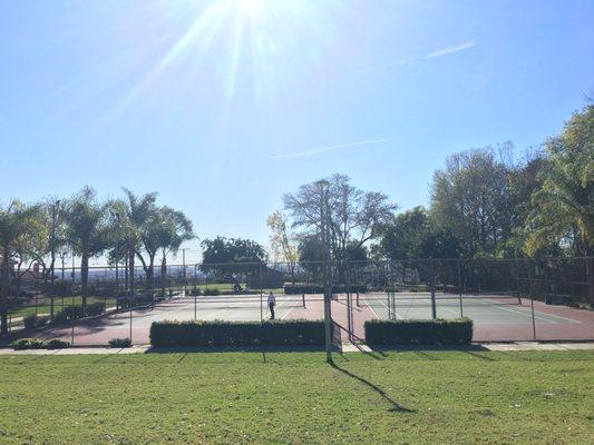 Two tennis courts seen above the hill.