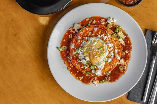 A classic enchilada with queso fresco, green onions layered betwen