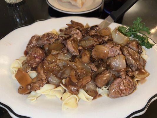 Tenderloin tips with onion and mushrooms over pasta.