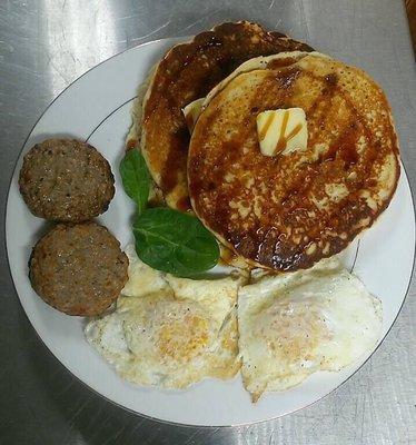 Gluten free Hemp, Coconut, and Banana Pancakes with secret syrup, 2 eggs, and sausage. Saturday's brunch special!