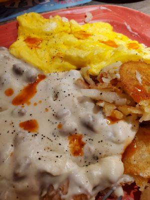 Sausage gravy & biscuits with a side of 3 scrambled eggs and home fries, a bit of hot sauce.