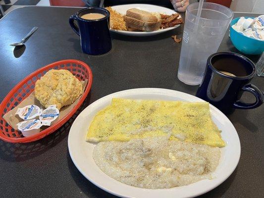 Omelette, grits, biscuit, & coffee.  And behind that, fried eggs, rye toast, bacon & coffee.  I added the pepper & butter.